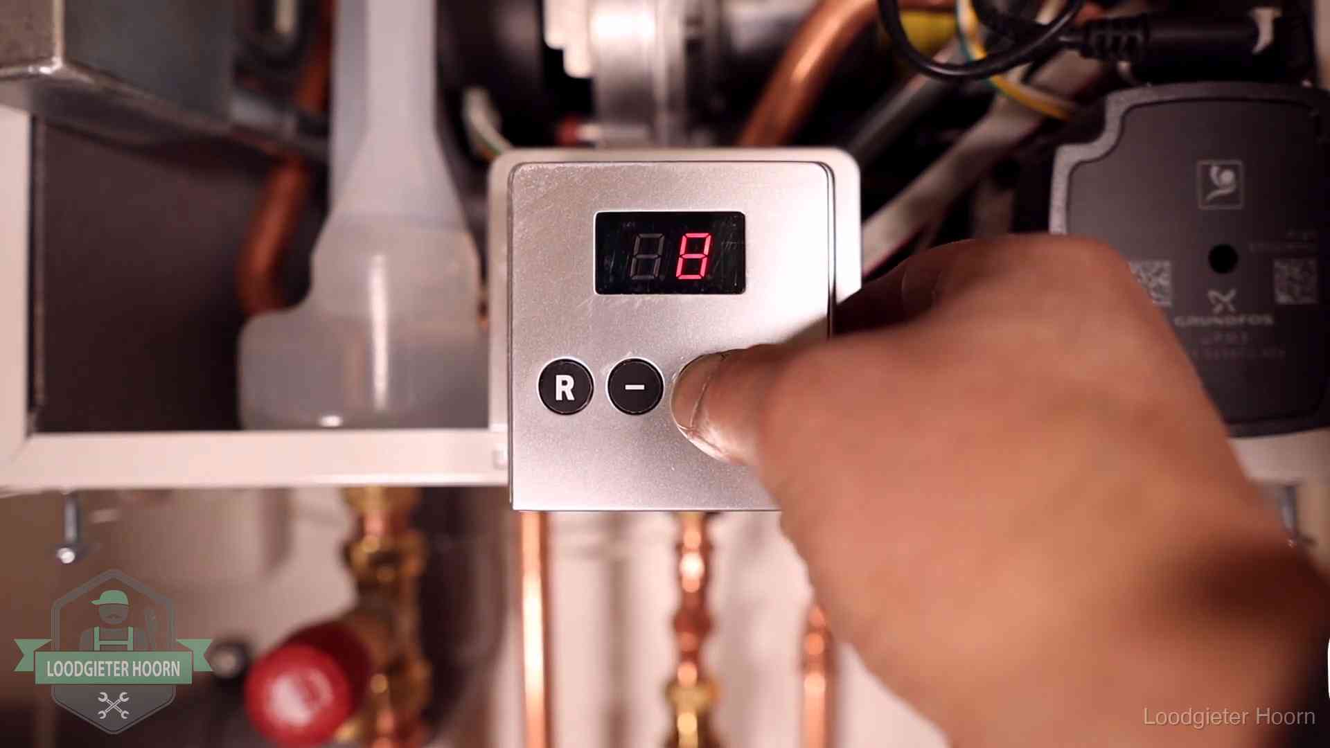 Monteur bedient het display van een cv-ketel bij een storing in Hoorn