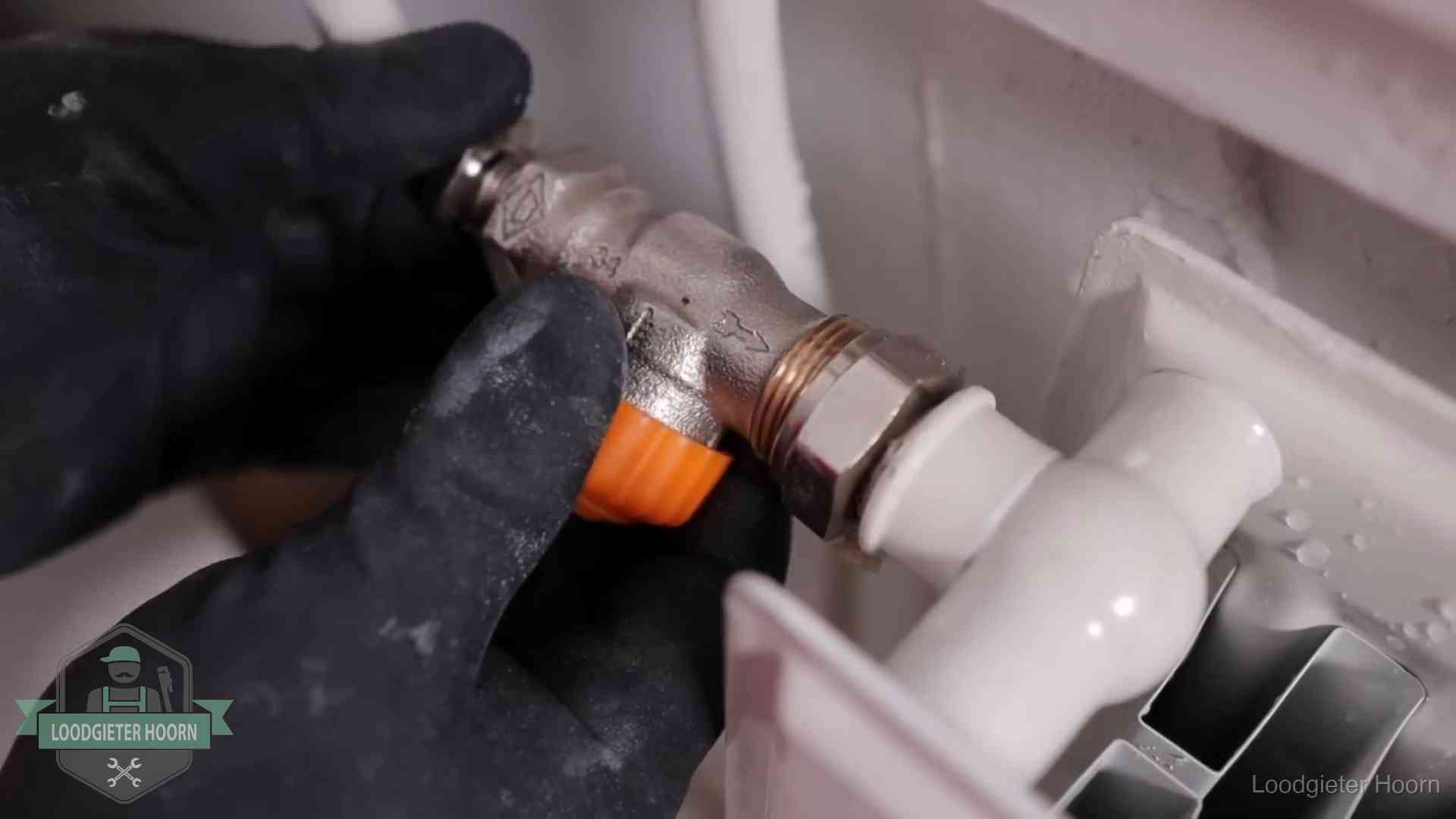 Thermostaatkraan wordt gemonteerd op een radiator in Hoorn voor het stookseizoen