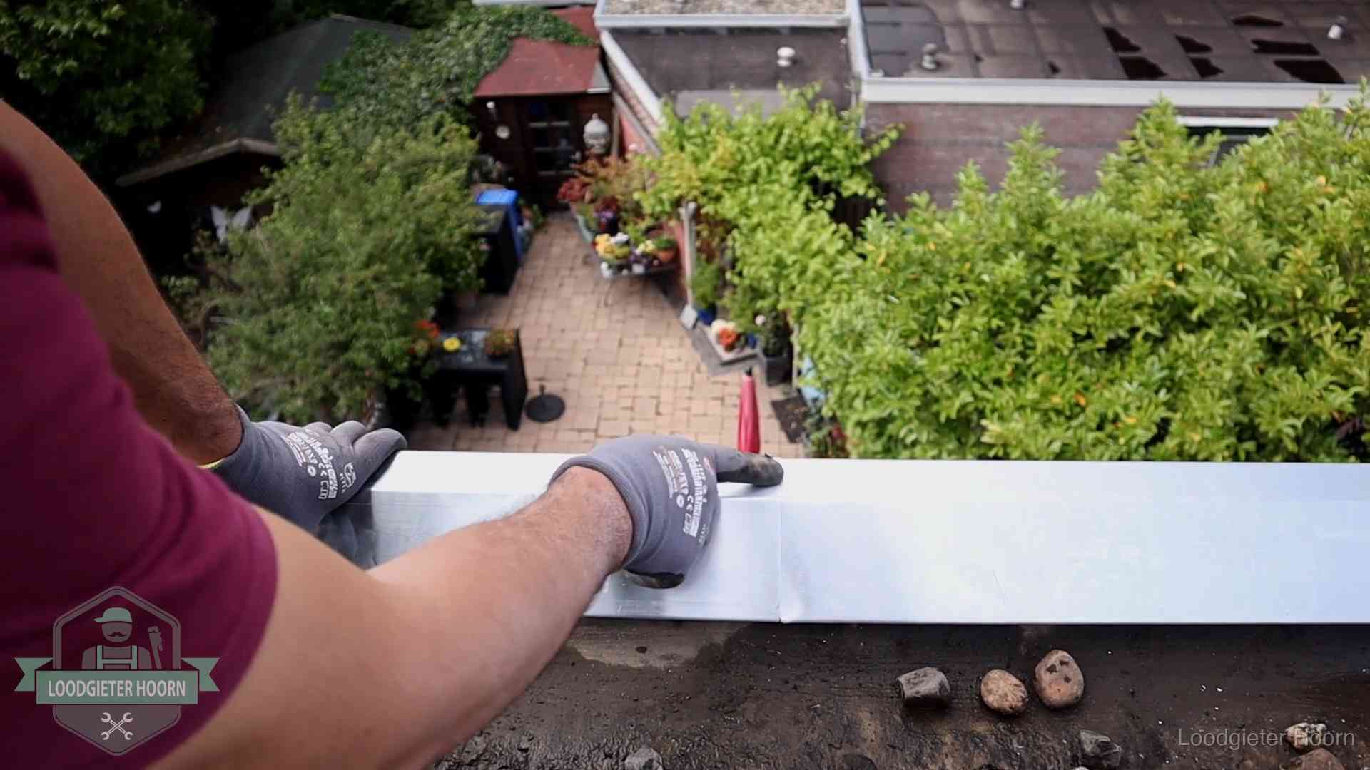 Daklekkage geregeld in Hoorn Vakman plaatst een daktrim op de dakrand van een woning in Hoorn
