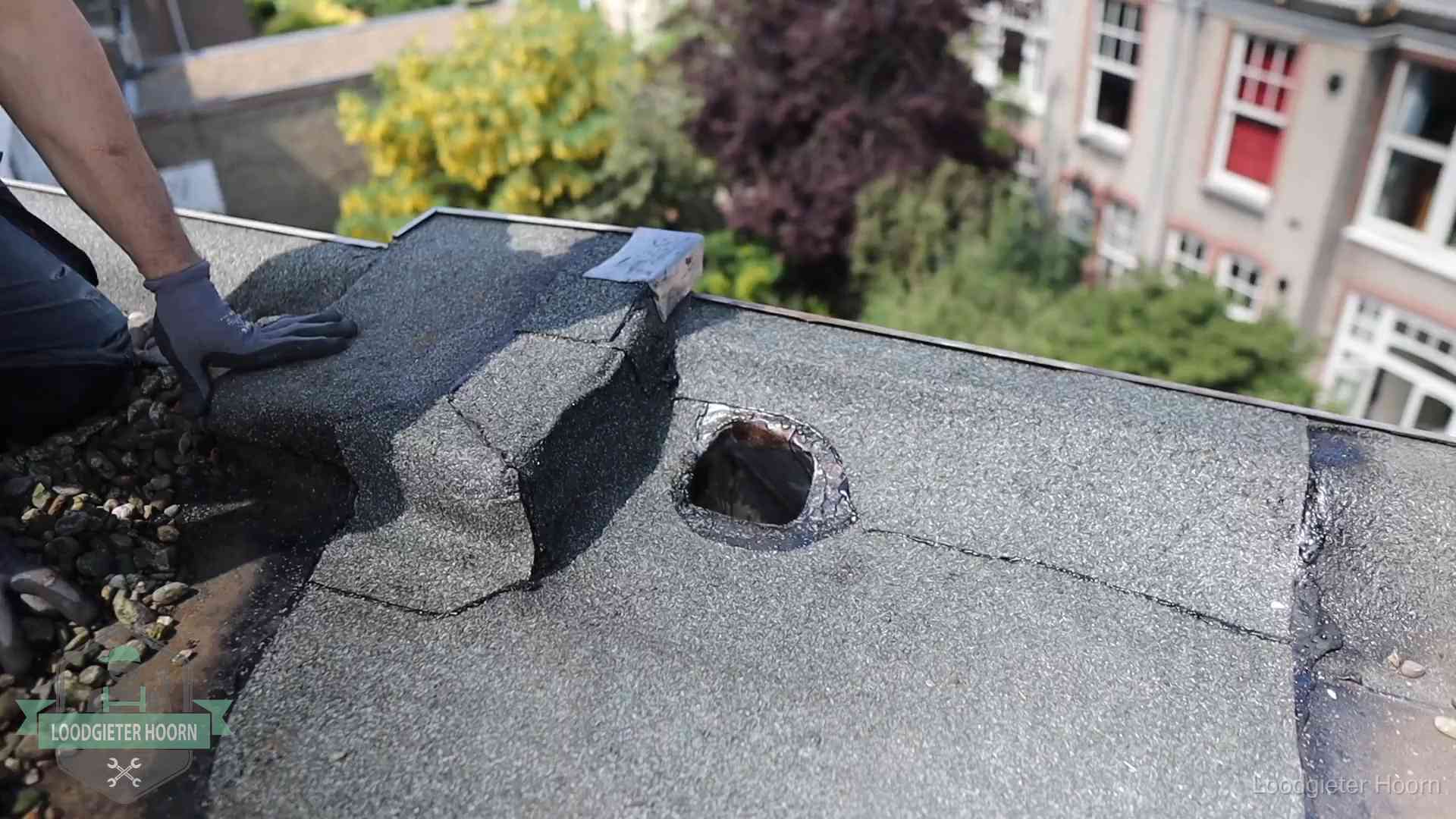 Daklekkage-inspectie op een plat dak in Hoorn Loodgieter inspecteert een beschadigd bitumen plat dak tijdens een daklekkage-inspectie in Hoorn