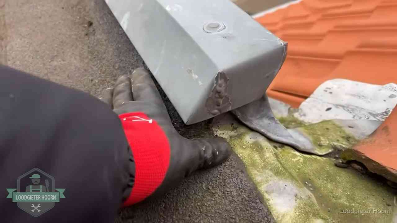 Hemelwaterafvoer en dakgoot controleren in Hoorn Controle van een zinken hemelwaterafvoer met loodslab bij dakpannen in Hoorn