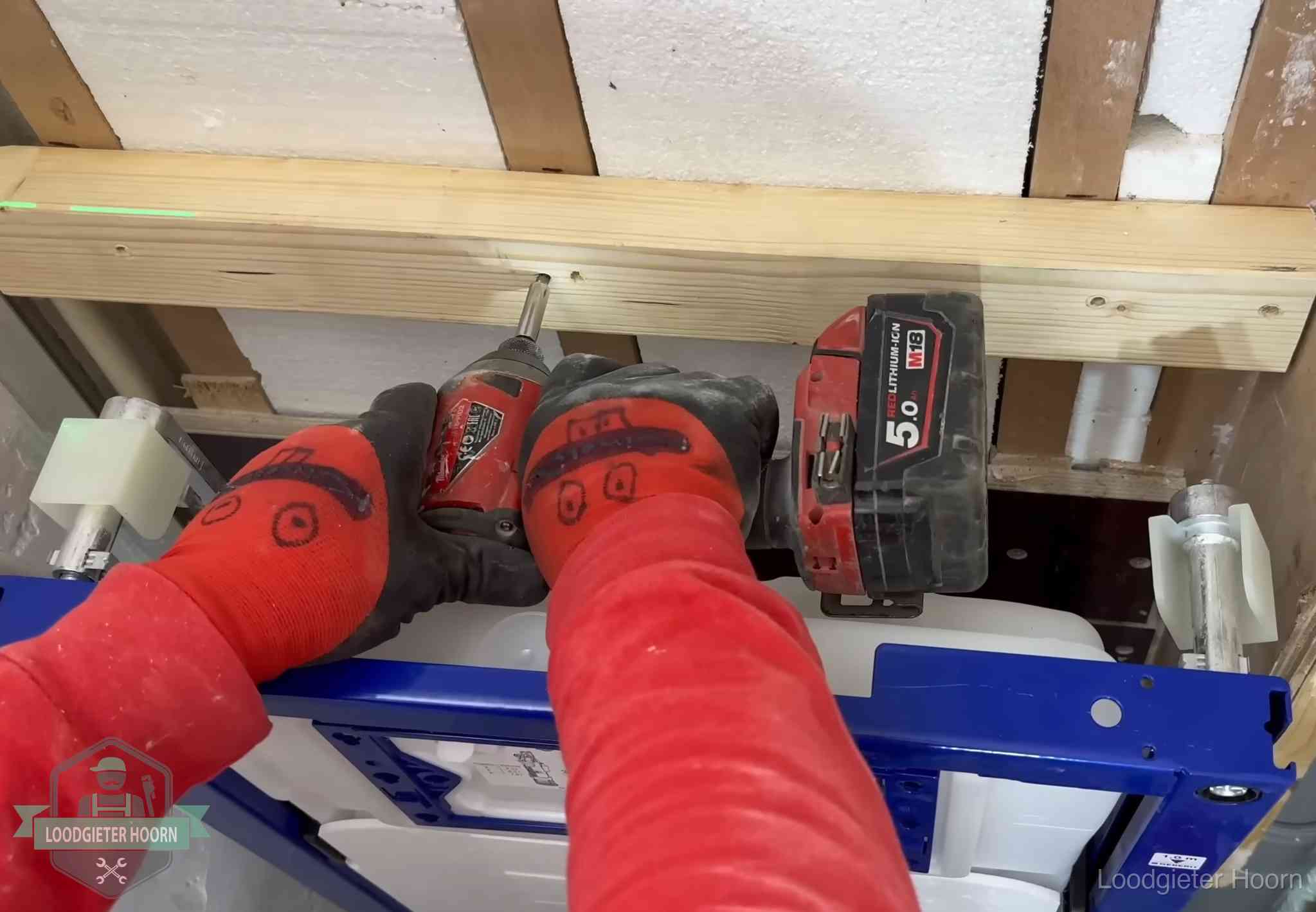 Monteur bevestigt een inbouwreservoir voor een hangend toilet in Hoorn