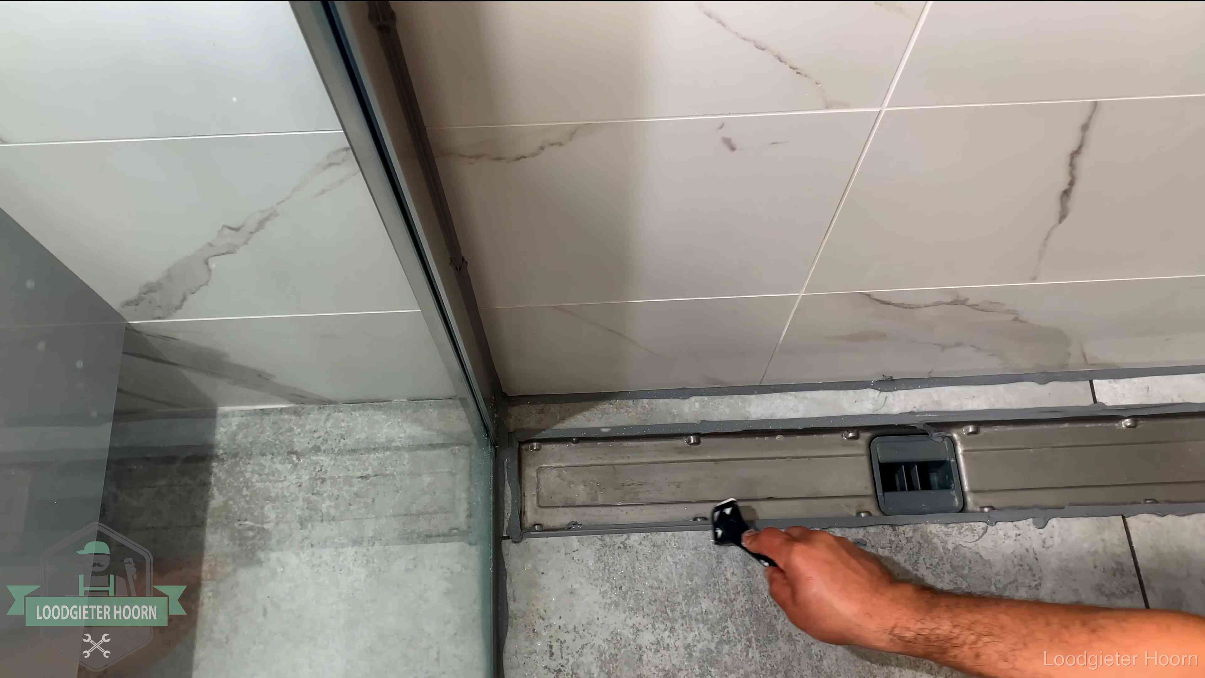Lekkage in de badkamer verhelpen in Hoorn Verse kitrand langs de douchegoot in een betegelde badkamer in Hoorn
