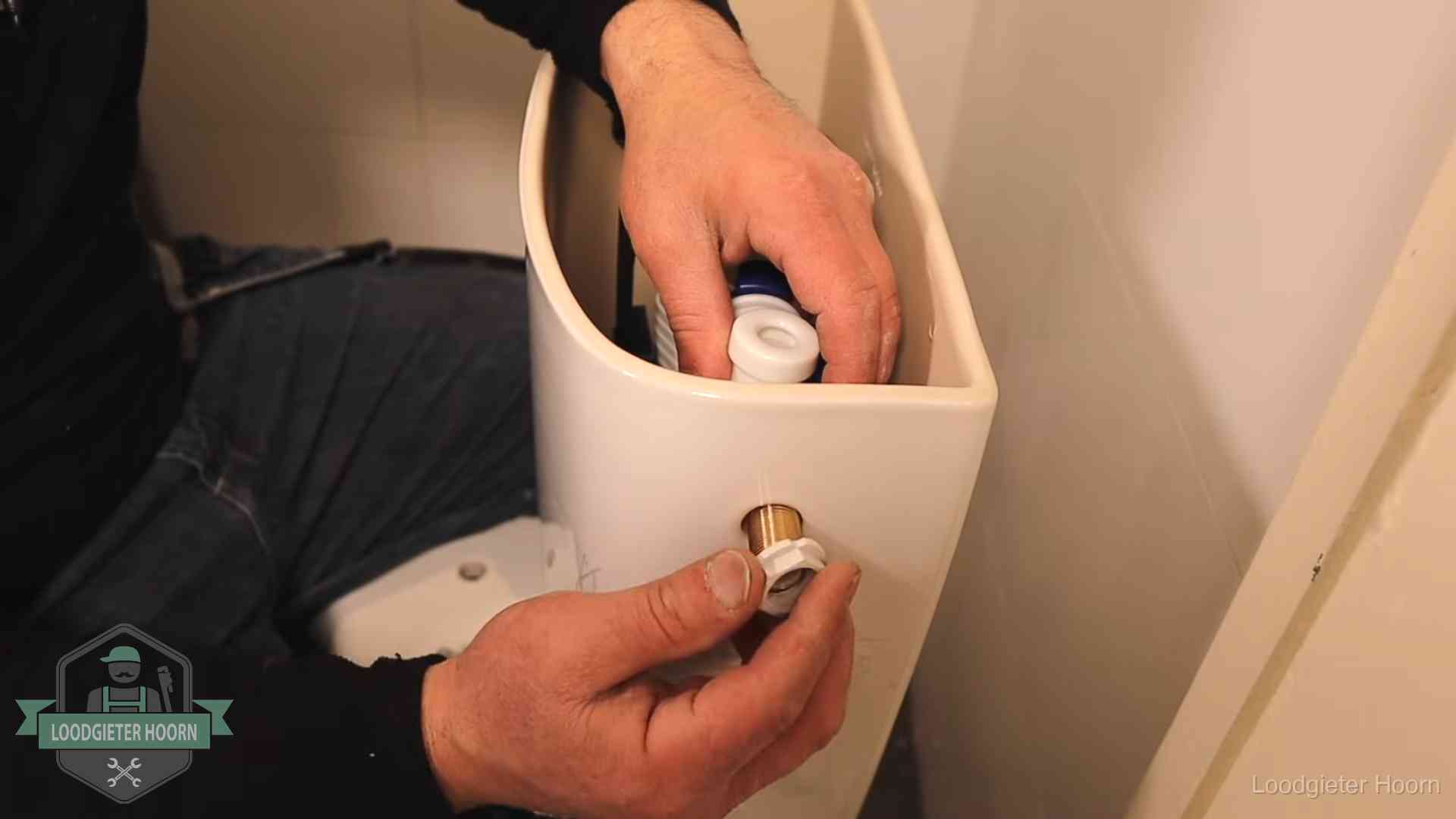 Loodgieter monteert de vlotterkraan van een stortbak bij een toilet in Hoorn