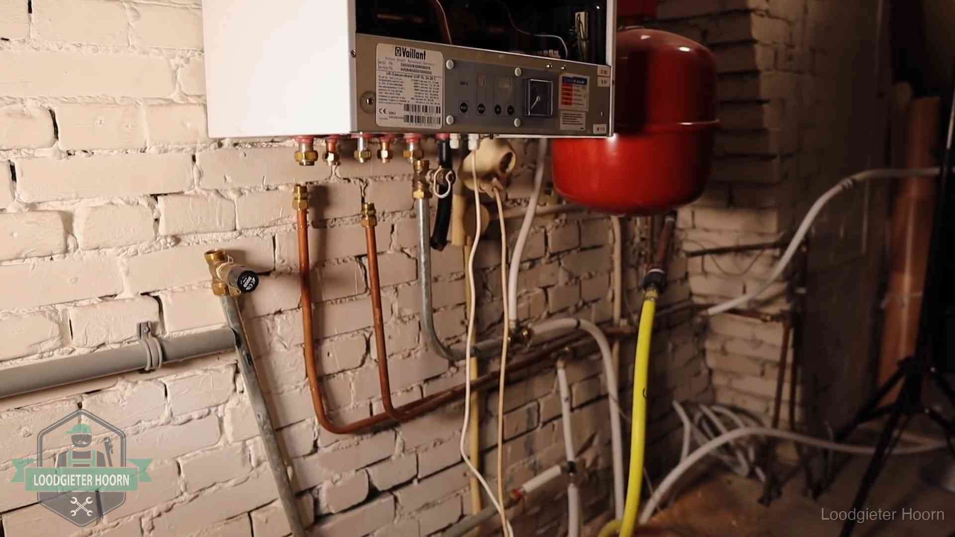 Verouderde cv-ketel met een wirwar van oude leidingen in een woning in Hoorn