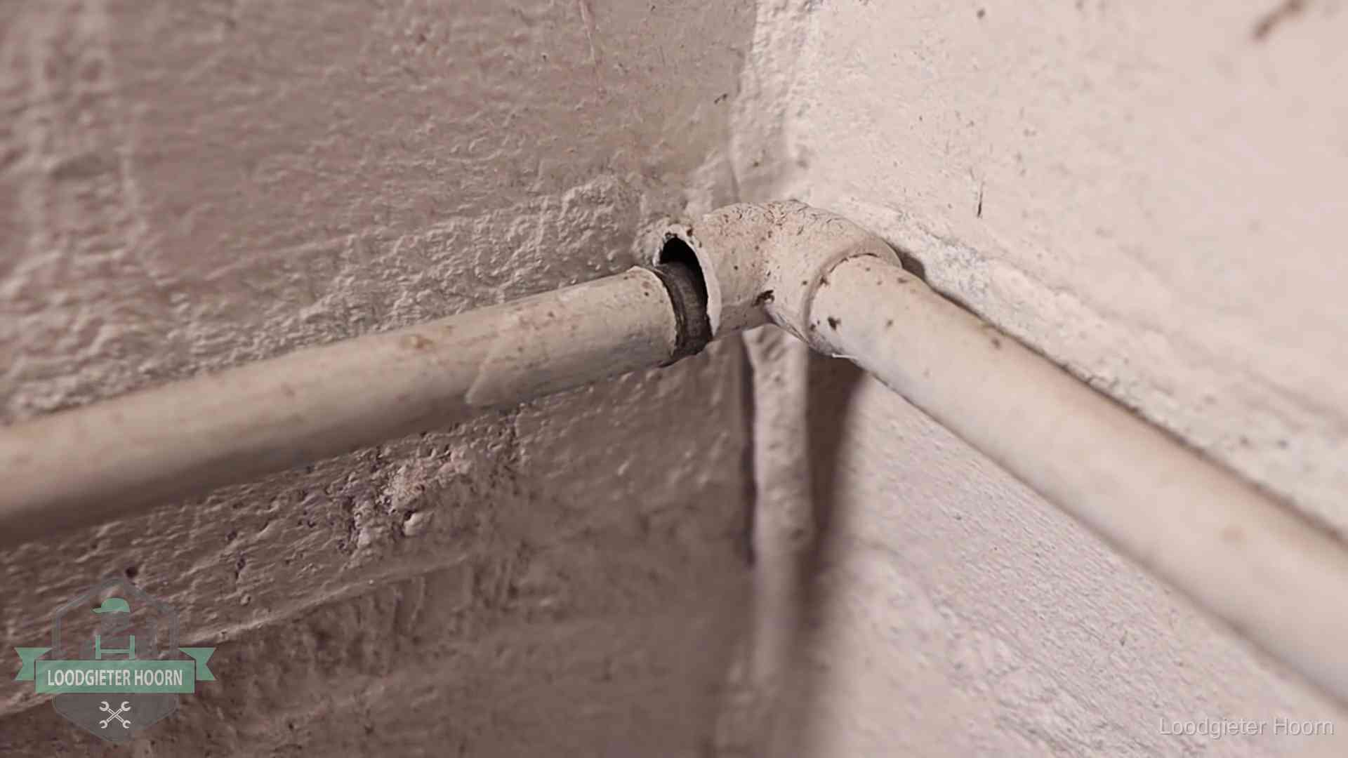 Oude waterleidingen en verborgen lekkage in Hoorn Oude geverfde waterleiding met een losliggende fitting in een woning in Hoorn