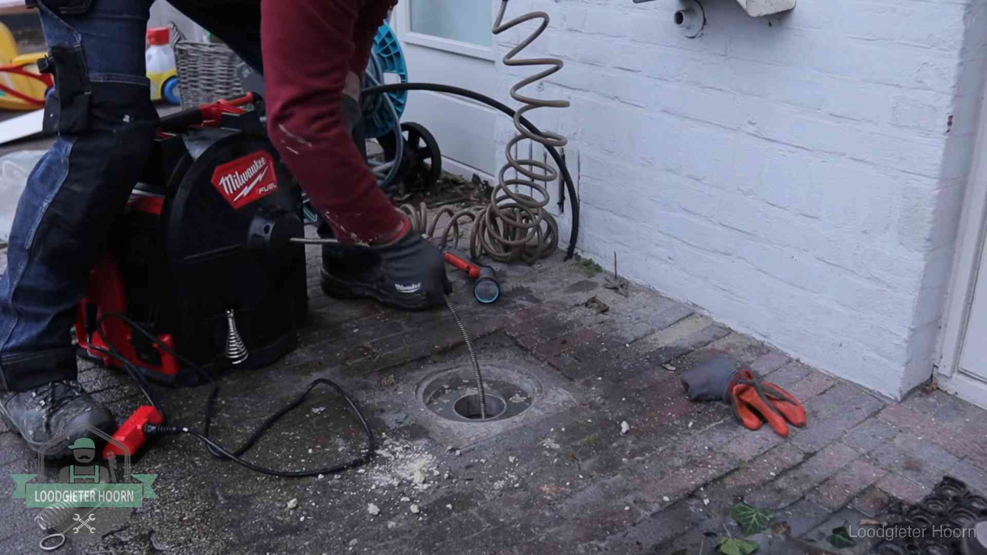 Spiraalmachine bij een ontstoppingsputje in de bestrating in Hoorn