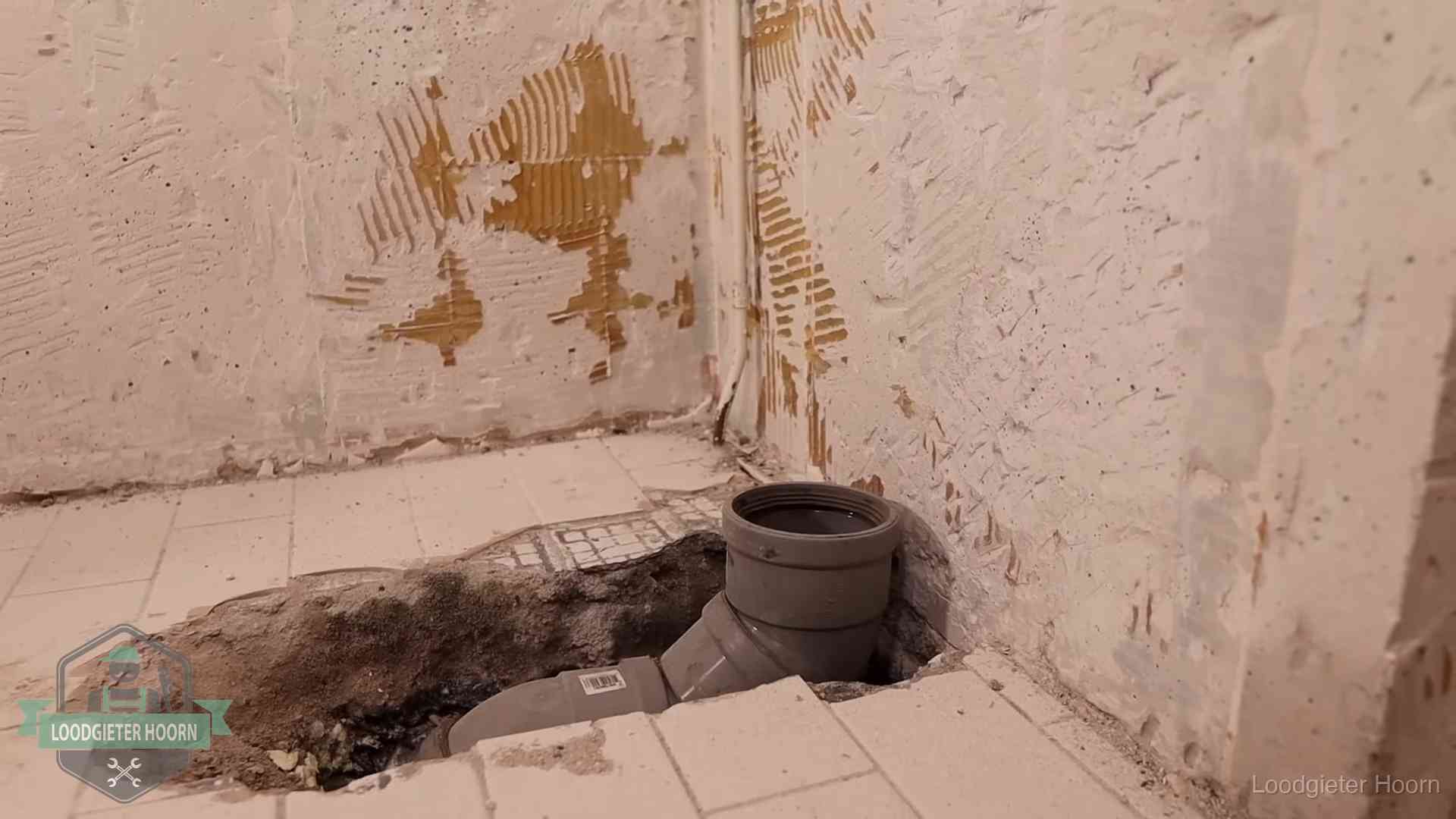 Opengebroken vloer met een nieuwe pvc-rioolbocht in een gegraven sleuf in Hoorn