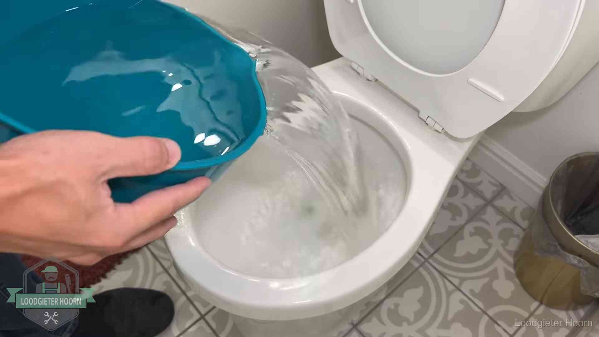 Warm water wordt voorzichtig in de wc-pot gegoten in Hoorn