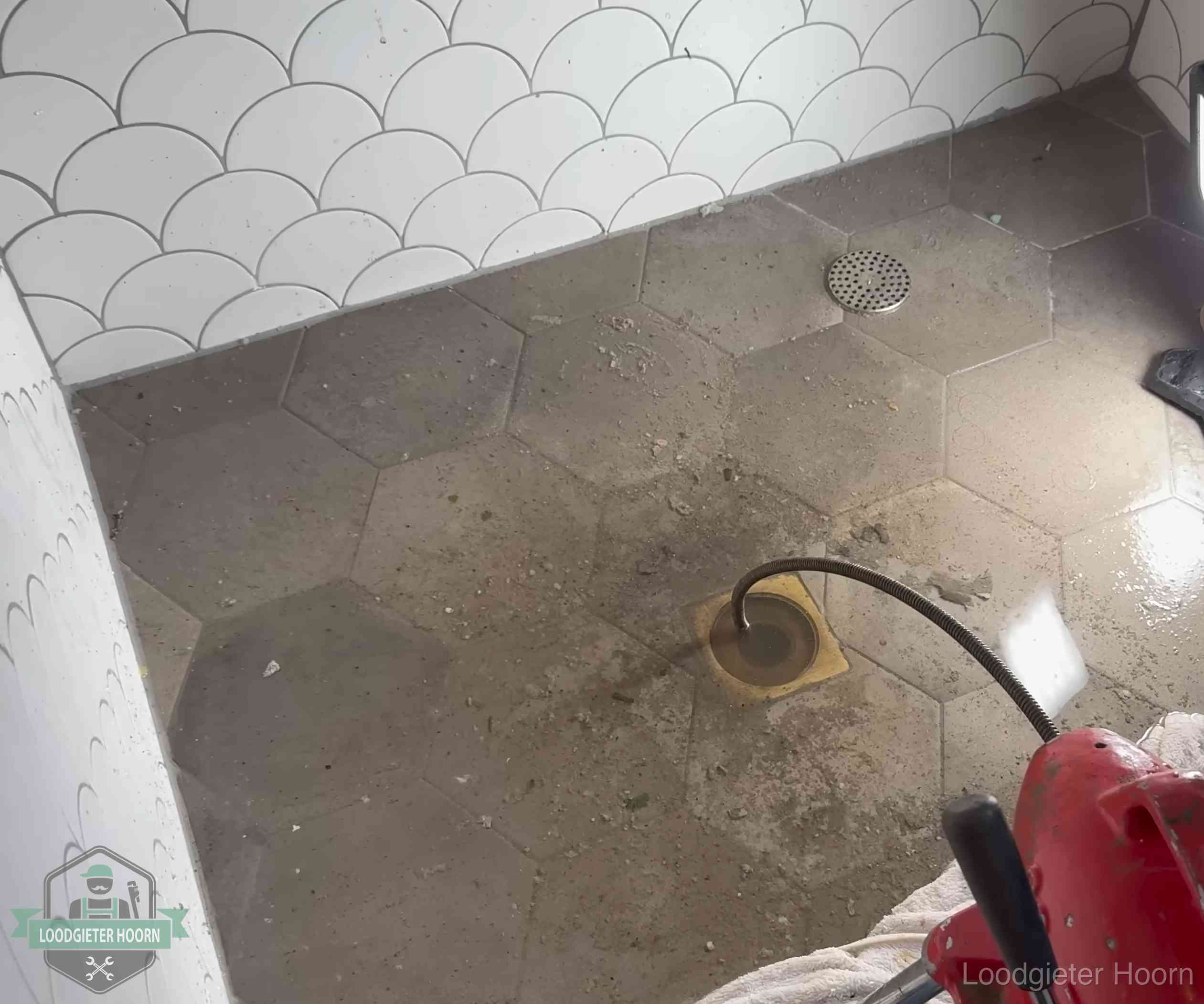 Vloerput met waterslot in een badkamer in Hoorn, een bron van stank als het waterslot droogstaat