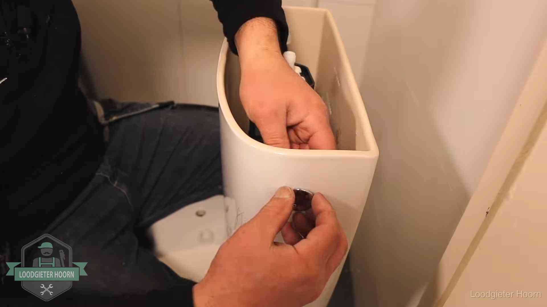 Drukknop van een duoblok-stortbak wordt gemonteerd bij een toilet in Hoorn