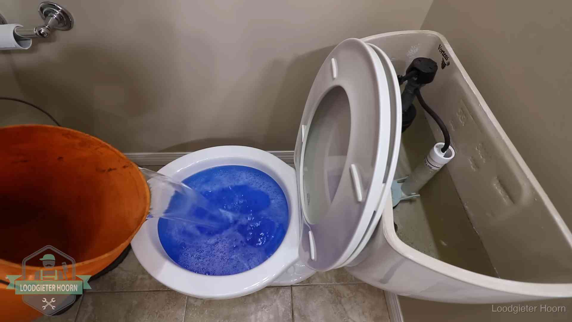 Water bij de wc-pot wordt met een emmer weggewerkt om schade te beperken in Hoorn